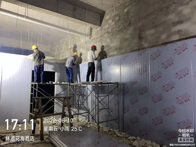 Workers installing cold storage panels