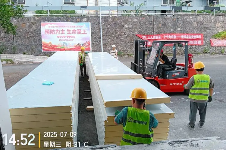 Workers moving cold storage panels