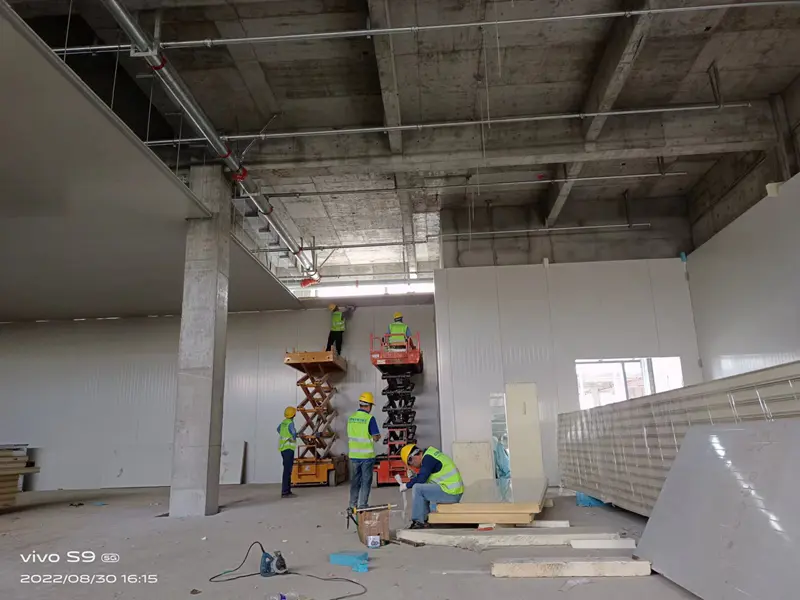 Workers installing cold storage panels