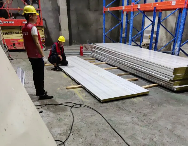 Workers are installing cold storage panels
