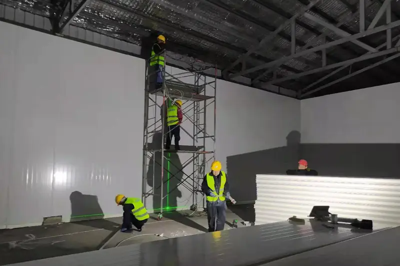 Workers are installing cold storage panels