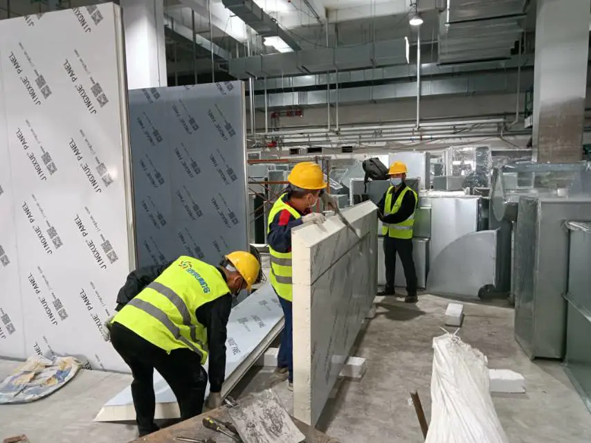 Workers are moving cold storage panels