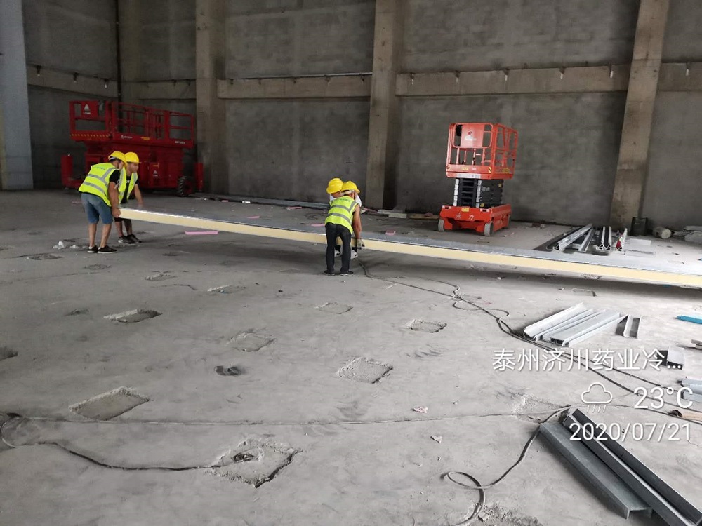 Workers are lifting cold storage panels