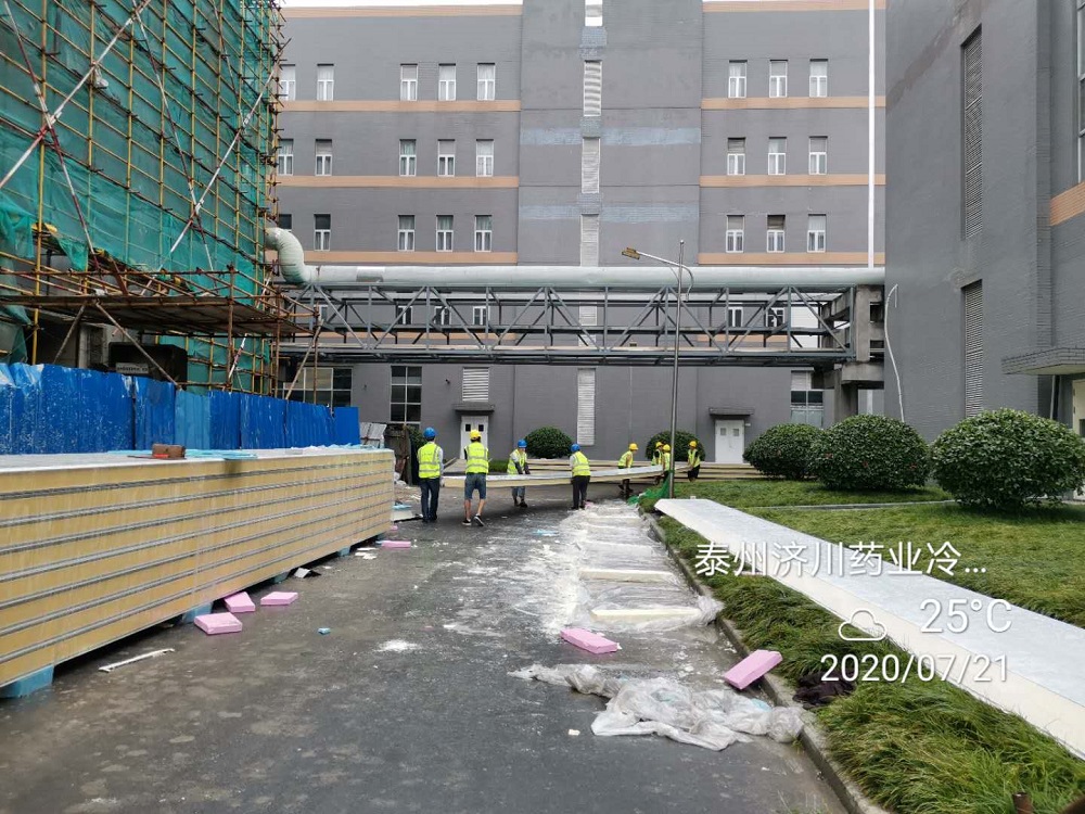 Workers are lifting cold storage panels